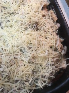 chicken tetrazzini topped with cheese and ready to go in the oven