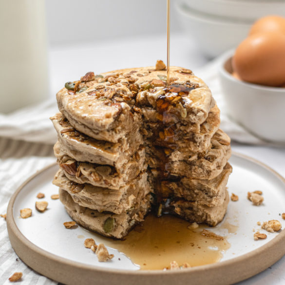 granola_pancakes_003_insta_2 a stack of granola pancakes with syrup drizzling down the sides