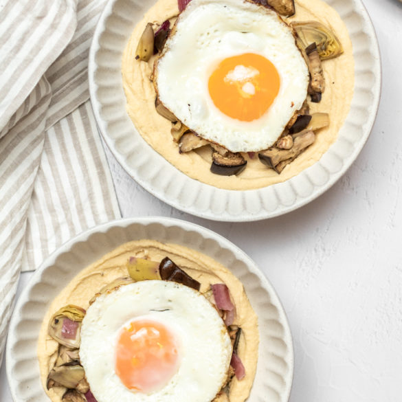 a pair of Mediterranean hummus and egg bowls with a side of naan
